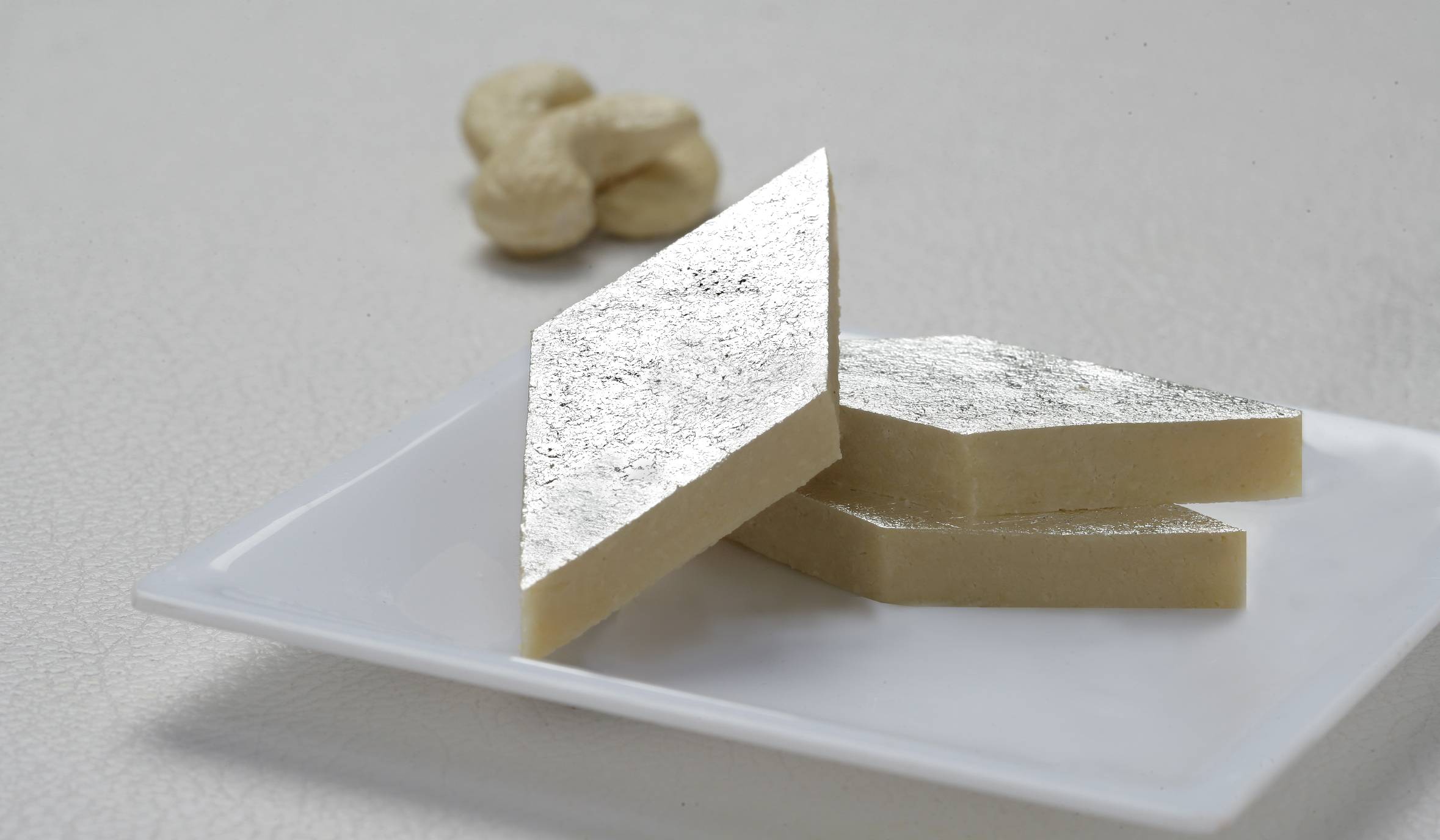 Macro close-up of kaju katli diamonds with edible silver leaf